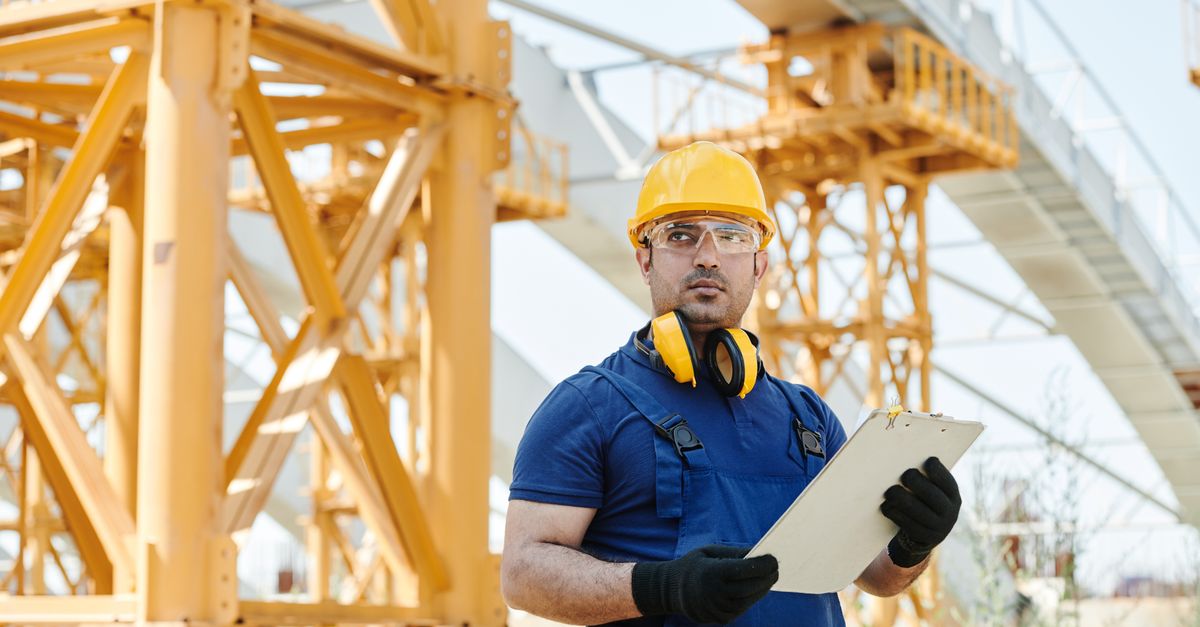 Building inspector in safety gear conducting a site inspection with a clipboard
